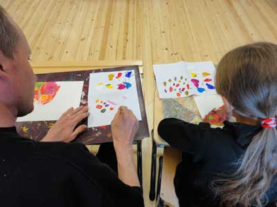 children and parents are painting a part of their environment