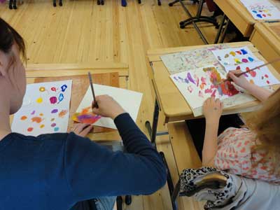 children and parents are painting a part of their environment