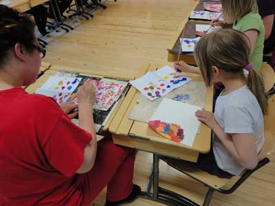 children and parents are painting a part of their environment