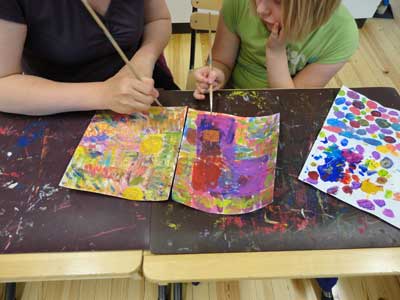 children and parents are painting a part of their environment