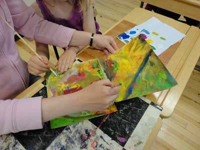 children and parents are painting a part of their environment
